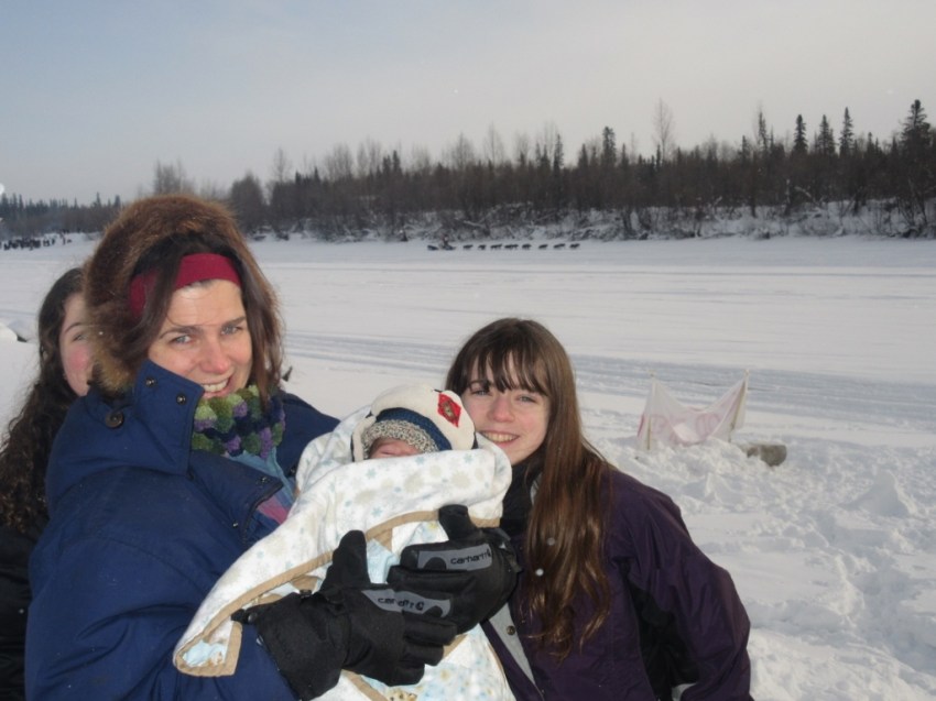 Standing in front of the Chena River, sled team in the distance