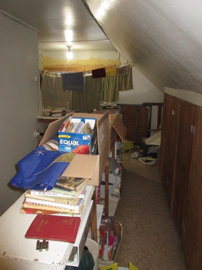 Upstairs storage area/clothesline/future boys' sleeping area. Still sorting through lots of books and materials found in the house.